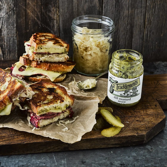 Holzplateau mit getoastetem Sandwich und Pickles und der Dill Mustard Sauce von Tracklements