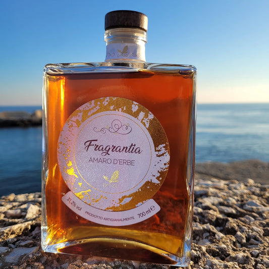 Eine Flasche Amaro Fragrantia mit dem Meer im Hintergrund