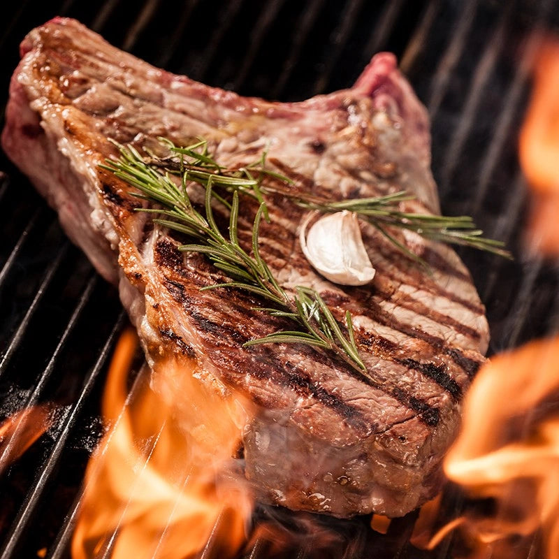 Ein Steak am Grill mit Rosmarin und Knoblauch